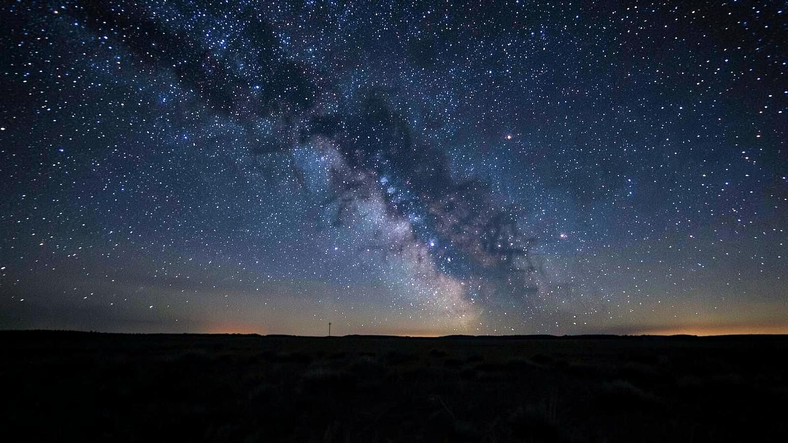 The Milky Way glowing over a still dark landscape at night