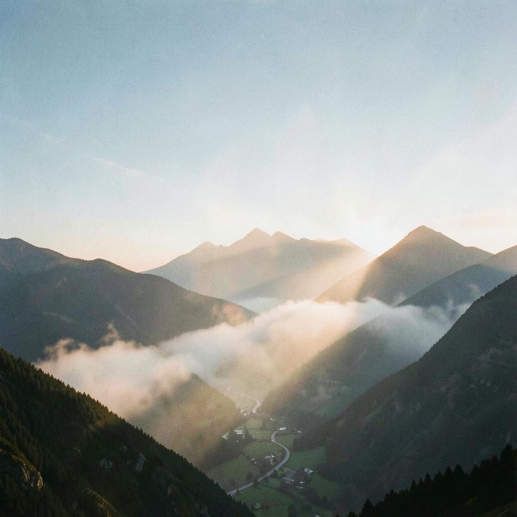 Sunrise breaking over mountain ridges above a valley filled with morning mist